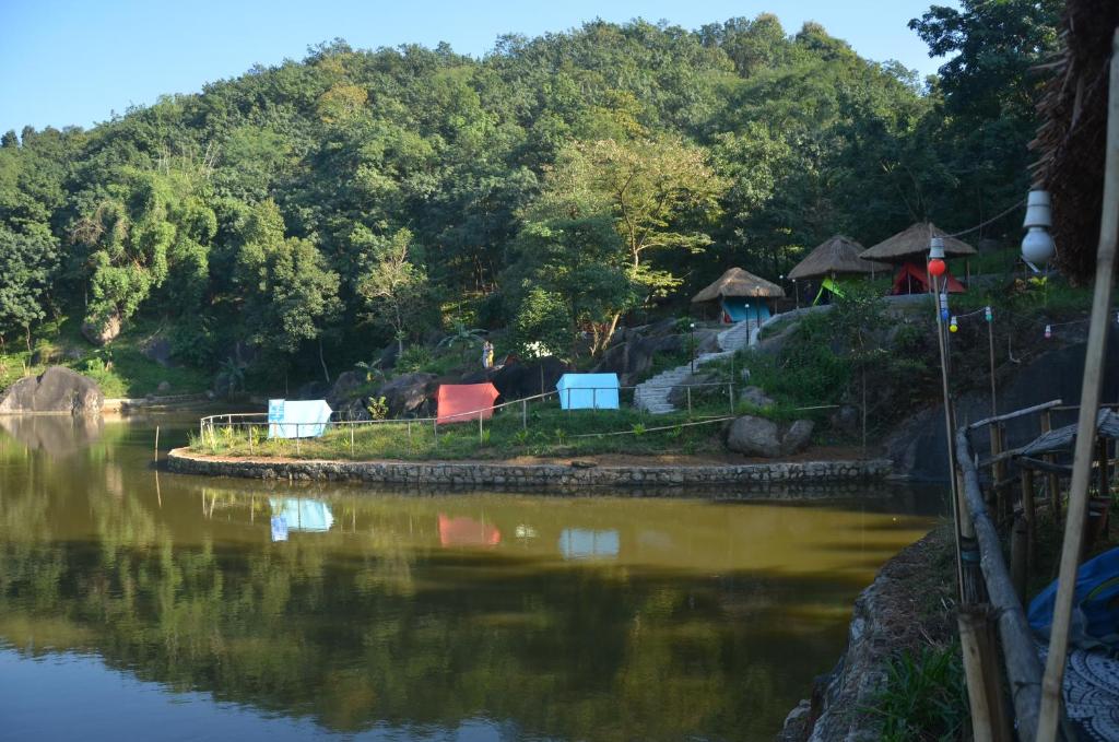 Vue sur une rivière avec des arbres en arrière-plan dans l'établissement Khanapara Hilltop Camp, à Guwahati