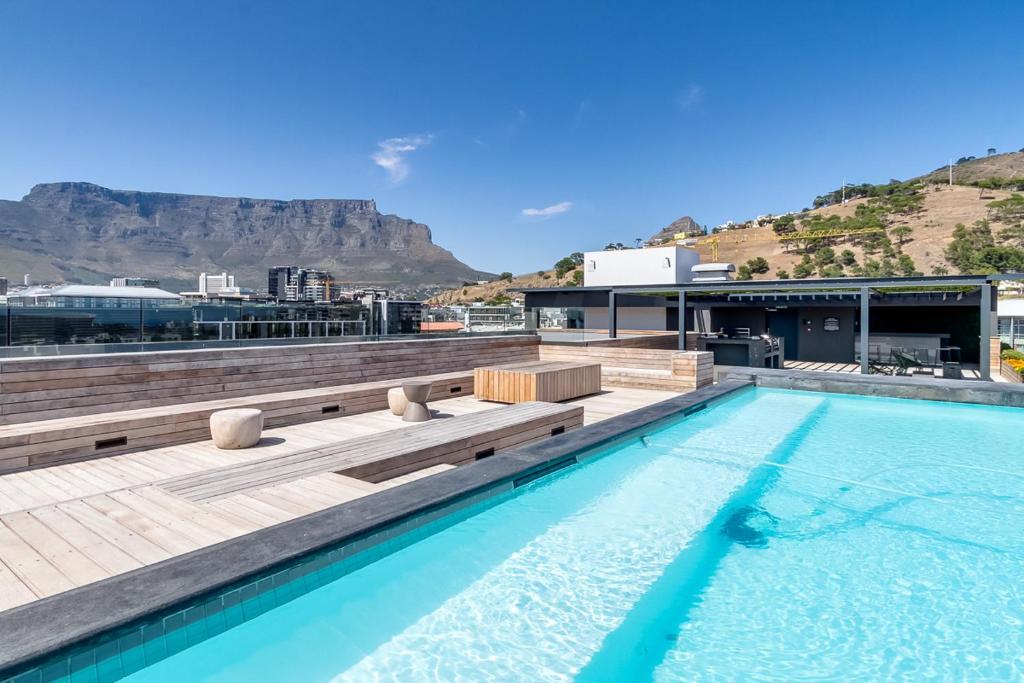 a swimming pool on top of a building with a mountain at Urban Elephant. The Docklands in Cape Town