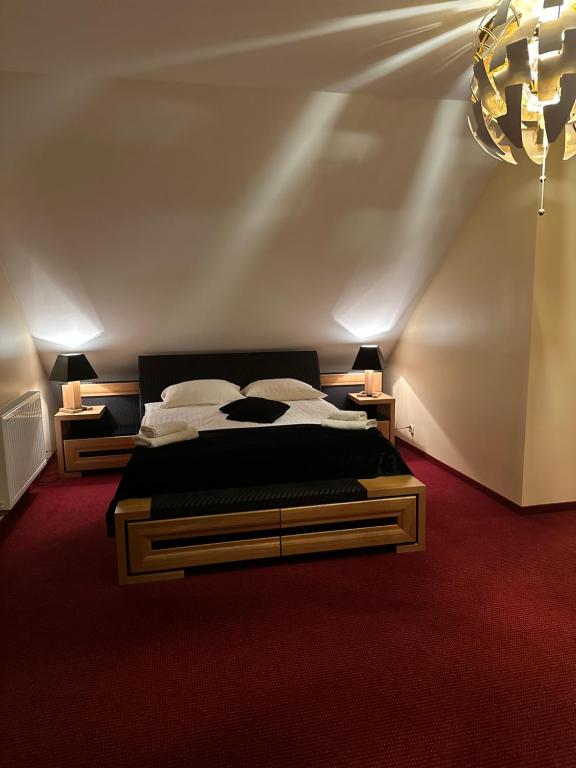 a bedroom with a bed and a chandelier at Restauracja i Hotel Oberża Wilczy Głód in Krzyszkowice