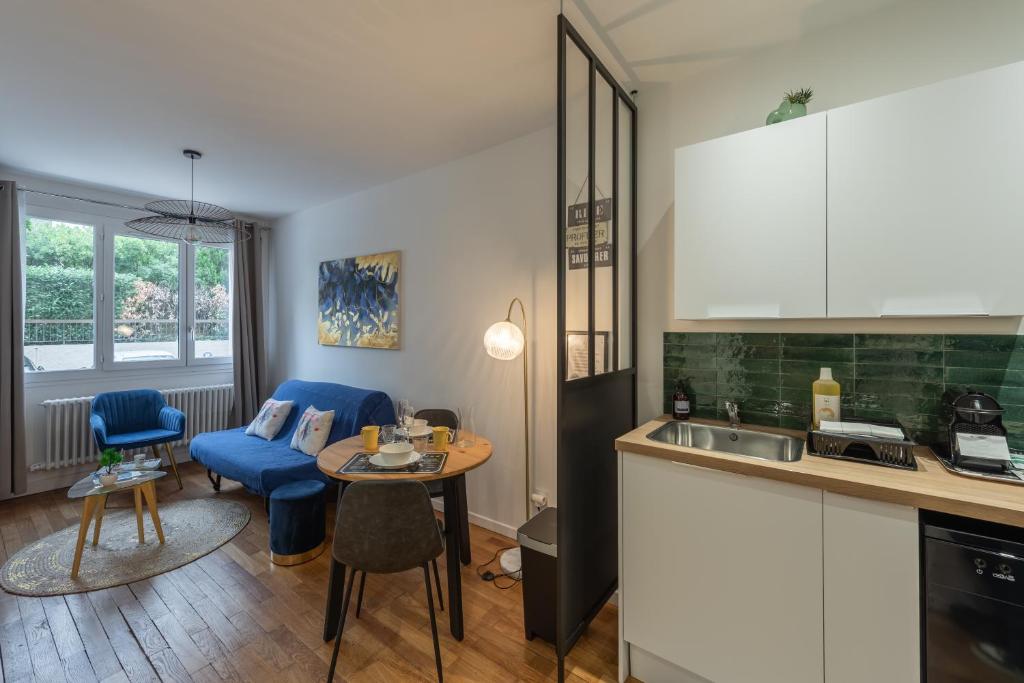 a kitchen and living room with a table and chairs at Cosy Vendôme - A 5min du Parc de la Tête dOr in Lyon