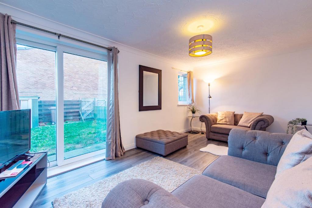 a living room with a couch and a large window at Bodmin House - Charming 3-Bedroom Terrace House with Private Enclosed Garden in Wallsend