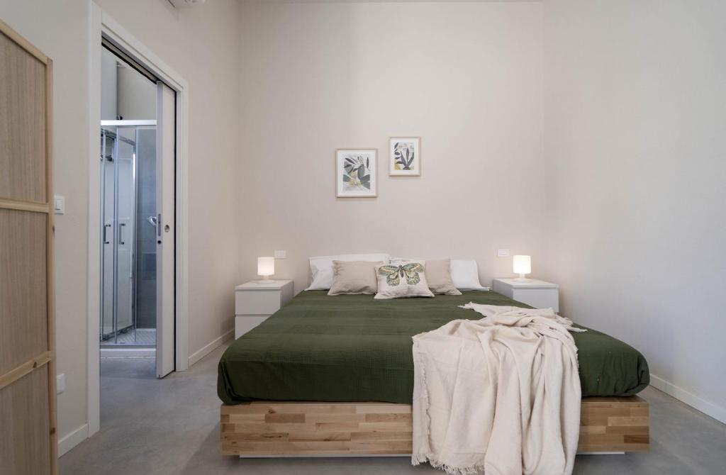 a bedroom with a bed with a green blanket on it at Casa del Falegname - Loft Noce con cucina in San Giovanni in Bosco