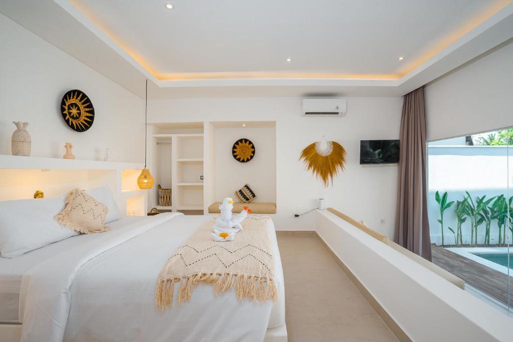 a bedroom with a white bed and a window at Villa Zahka - 1BR Private Luxury Hideaway near Seseh Beach in Canggu