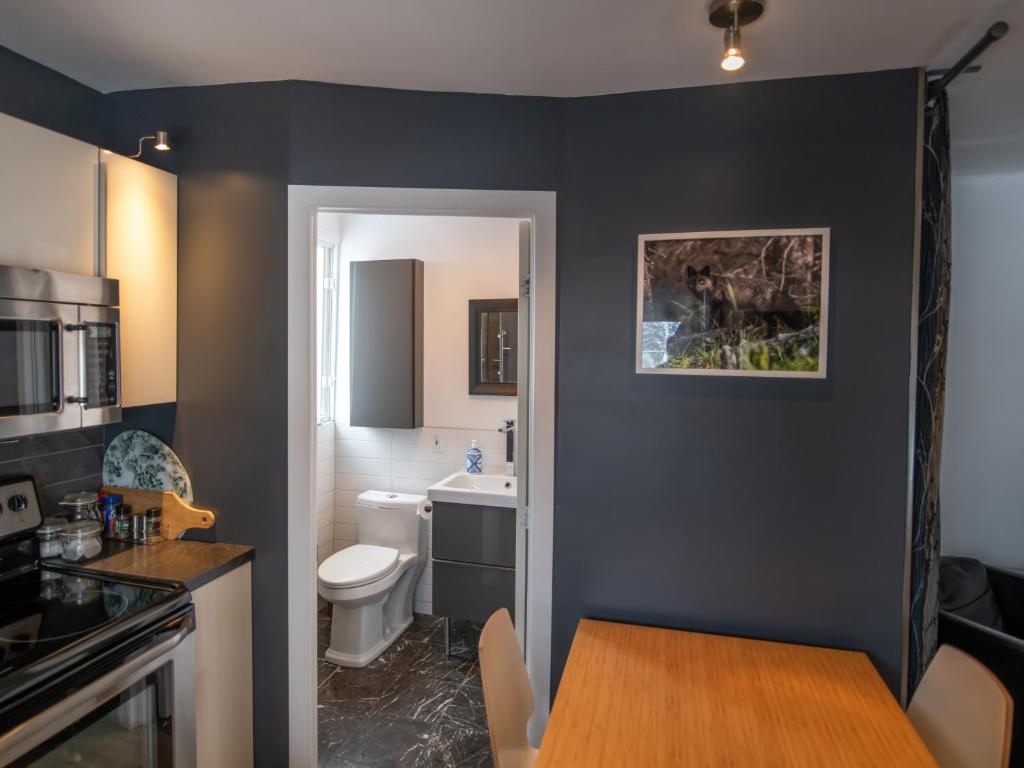 a kitchen with a dining table and a bathroom at Résidence Touristique Chicoutimi in Saguenay