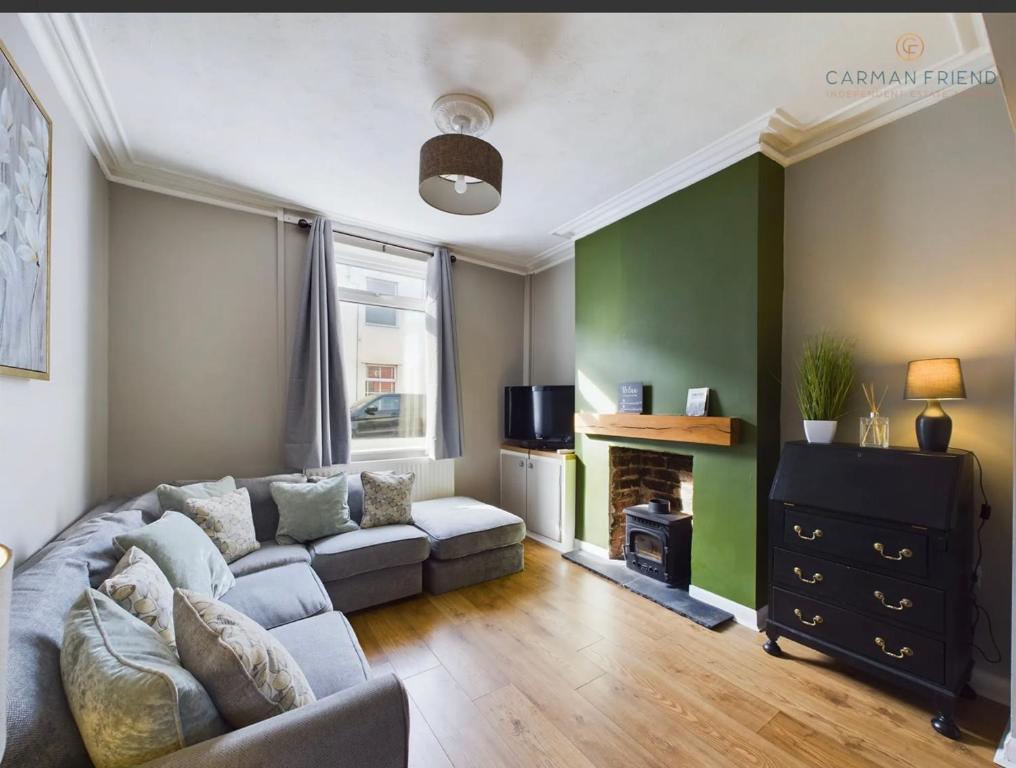 een woonkamer met een bank en een open haard bij The Terrace Hoole, cosy modern 2 bedroom house in Chester