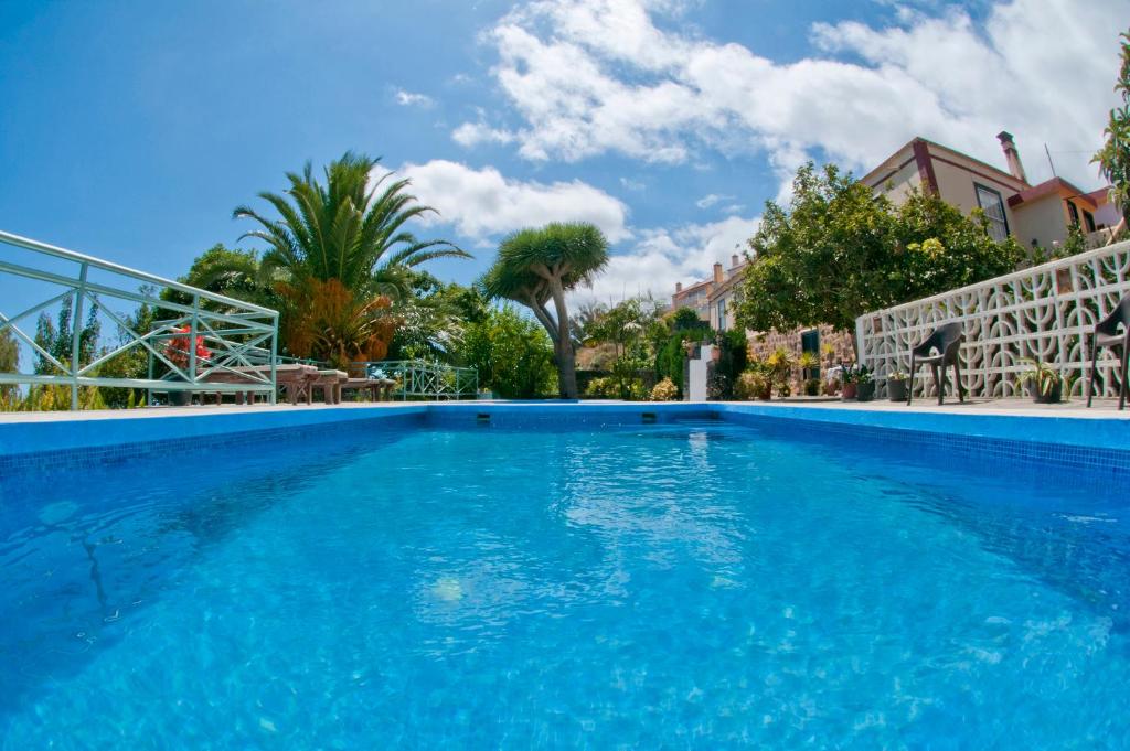 uma grande piscina azul com árvores e casas em Villa Asunción A em Breña Baja