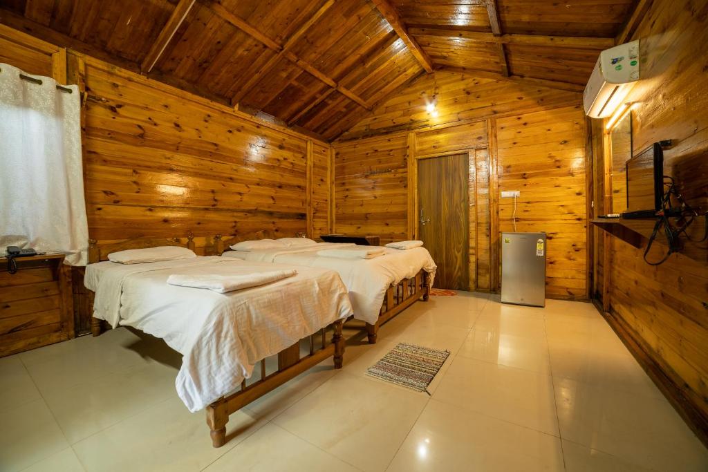 a bedroom with two beds in a wooden cabin at Oxygen Palolem in Palolem