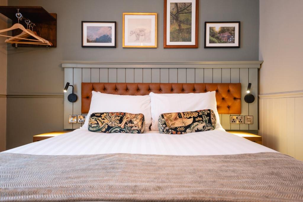 a bedroom with a large bed with two pillows at The Bears Head by Innkeeper's Collection in Sandbach