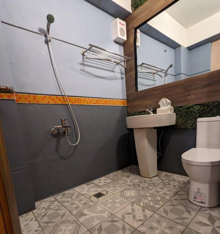 a bathroom with a sink and a toilet and a mirror at Blackport Seaview Homestay in Yanliau