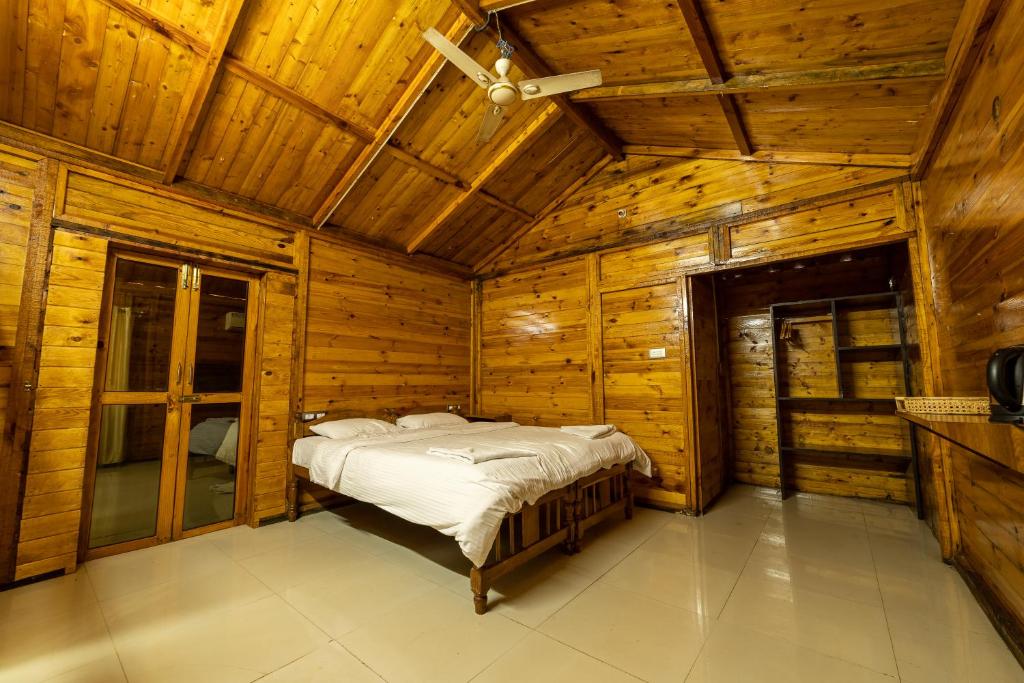 a bedroom with a bed in a wooden cabin at Oxygen Palolem in Palolem