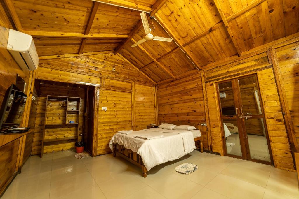 a bedroom with a bed in a wooden cabin at Oxygen Palolem in Palolem