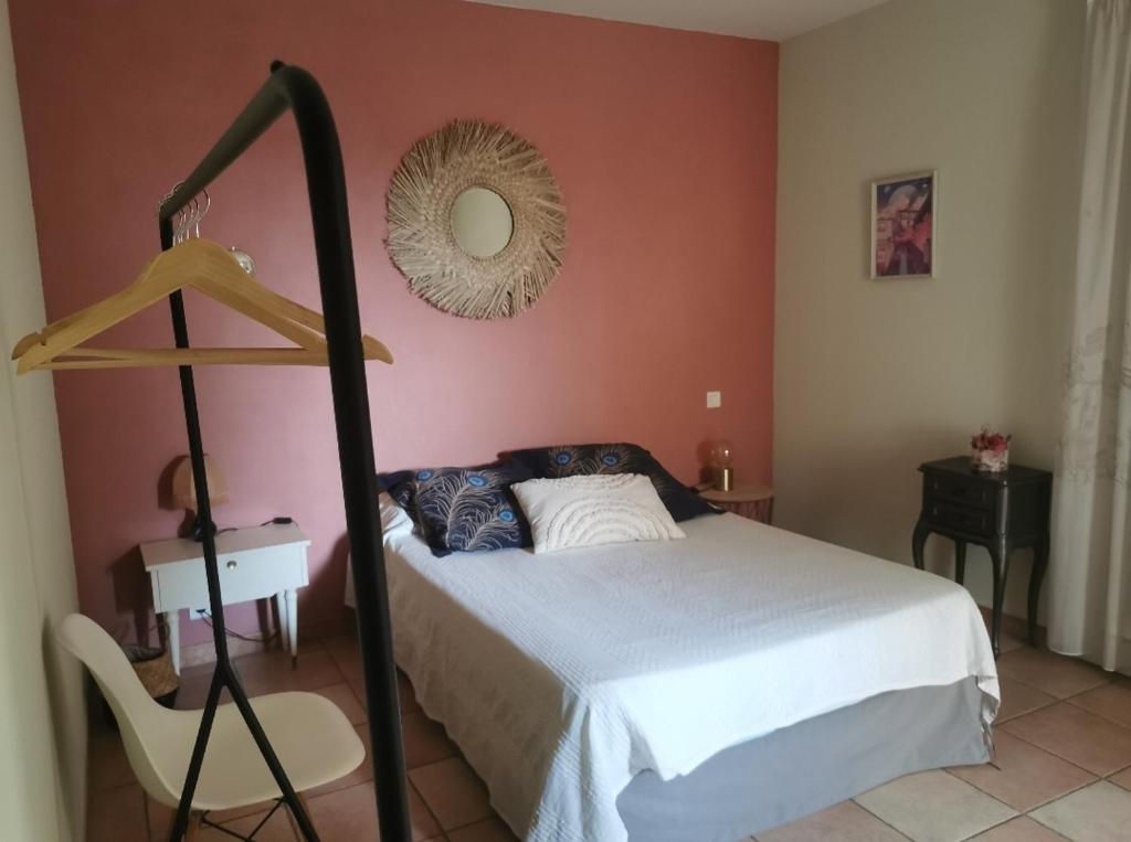 1 dormitorio con cama, espejo y silla en Chambre privée cosy, salle de bain et terrasse, en Millas