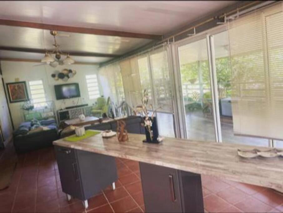 a kitchen with a large counter top in a living room at Maison de campagne in Kourou