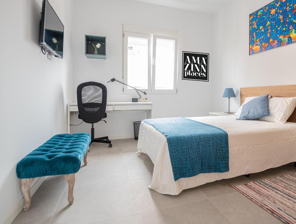 a bedroom with a bed and a desk and a chair at Habitacion a metros de la playa con cocina y WC compartida, terraza y zonas comunes in Valencia