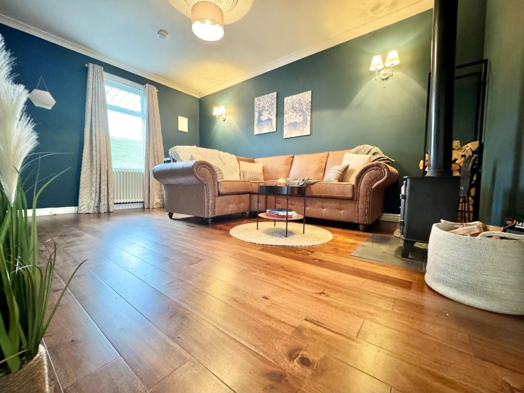 a living room with a couch and a table at Chestnut Cottage in Dalmellington