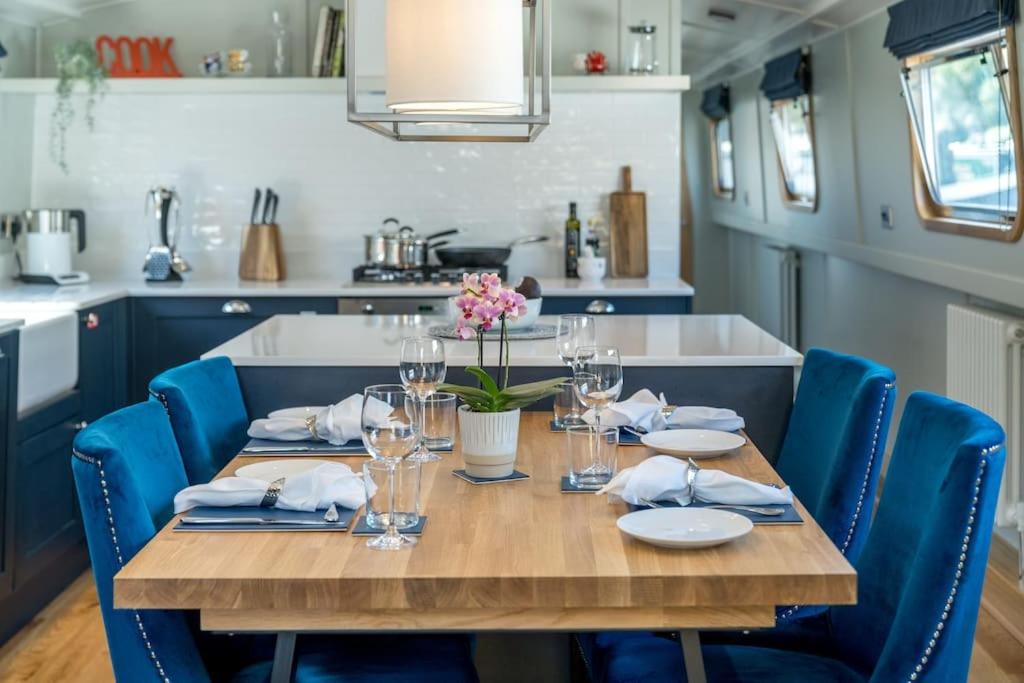 a table in a kitchen with blue chairs around it at Luxurious houseboat near Canary Wharf in London in London