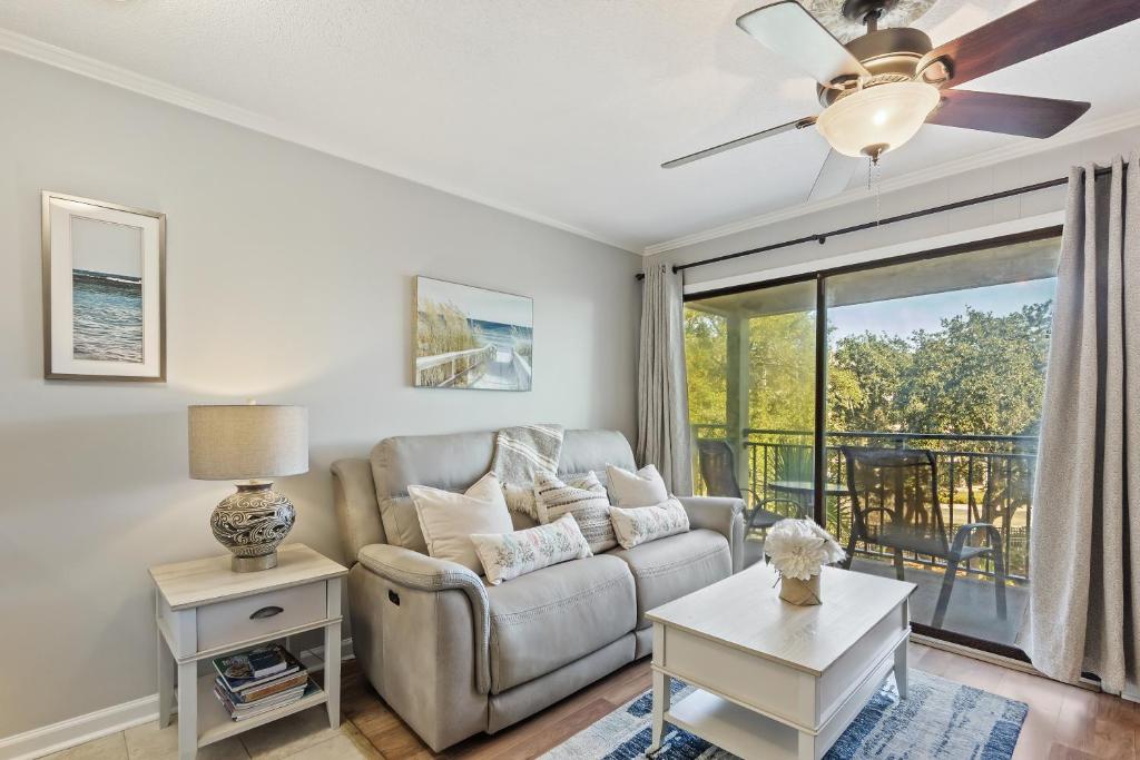 uma sala de estar com um sofá e uma ventoinha de tecto em Seaside Villa 251 em Hilton Head Island