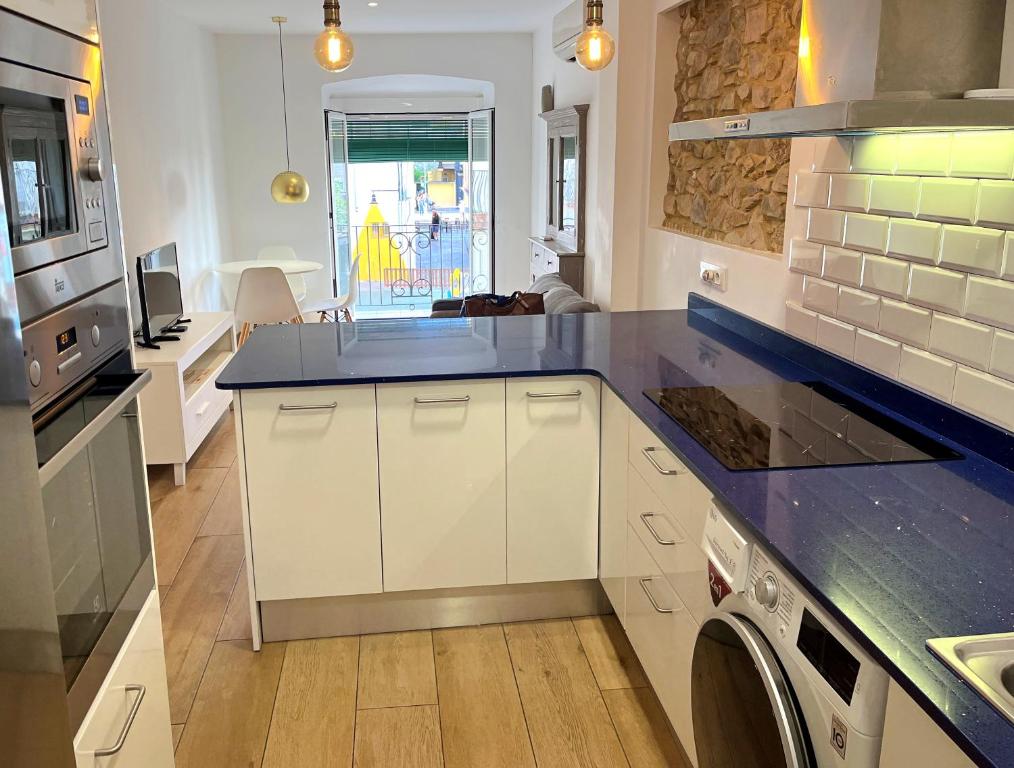 a kitchen with white cabinets and a blue counter top at Apartamento cerca de la playa in Blanes