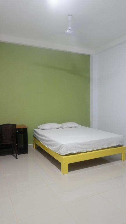 Mandati的住宿－Maria Guesthouse，绿色墙壁间的一张床位