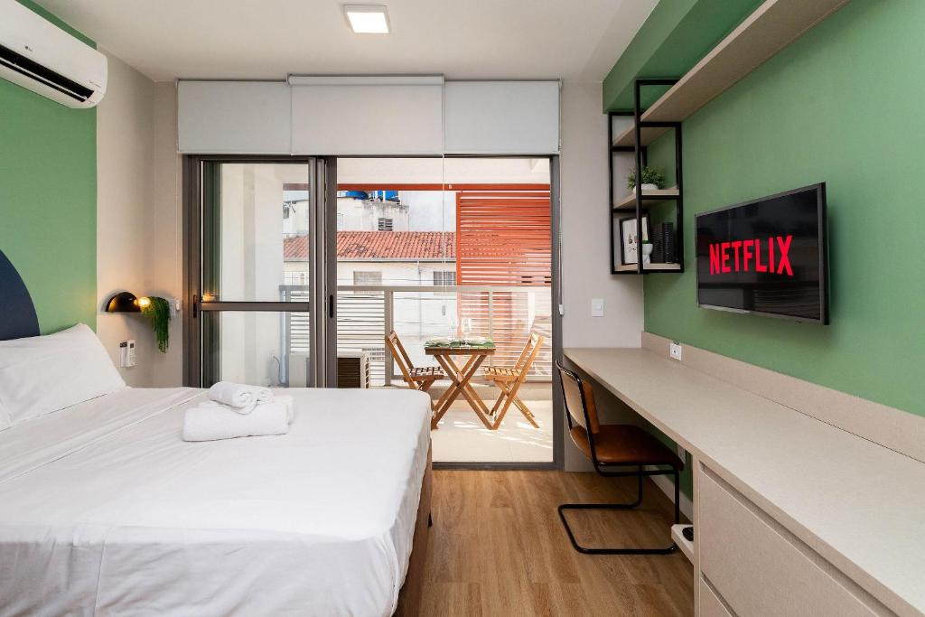 a bedroom with a bed and a desk with a view at Axis Vila Mariana - Studios por temporada in Sao Paulo