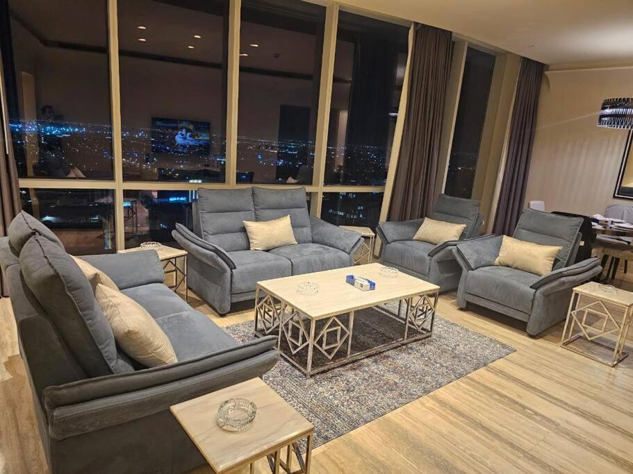 un soggiorno con divani e tavoli in un edificio di Luxury Towers Apartment in Downtown a Riyad