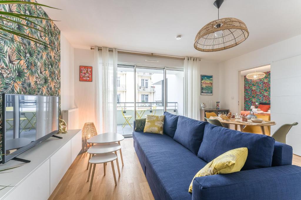un salon avec un canapé bleu et une télévision dans l'établissement Lima - Appt à proximité de lIle de Nantes, à Nantes