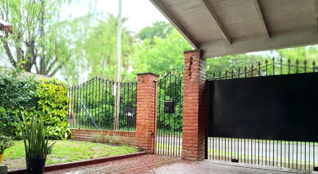 a black fence with a gate in a yard at Hostel Mia in Ezeiza