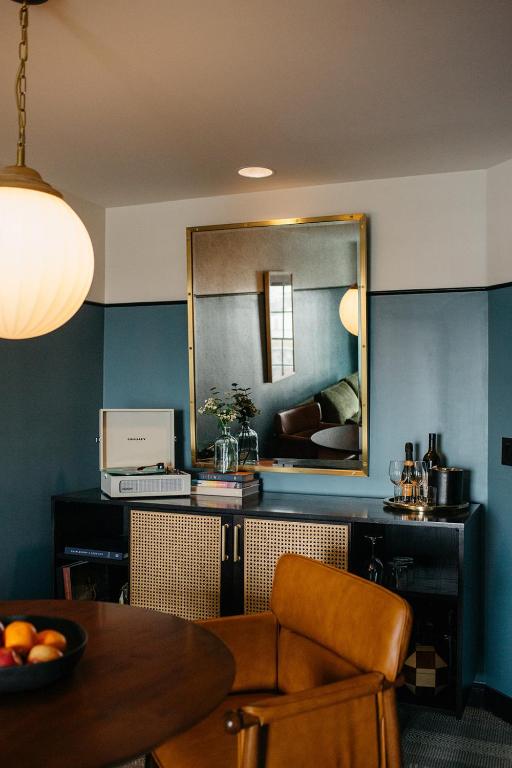 a living room with a table and a mirror at Hotel Emeline in Charleston