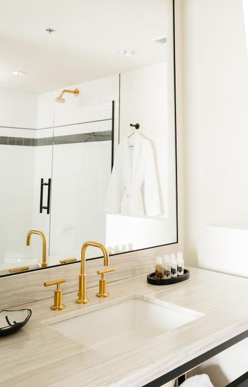 a bathroom with a sink and a mirror at Hotel Emeline in Charleston