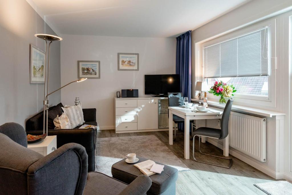 a living room with a couch and a table with a desk at Sonnenidyll in Westerland