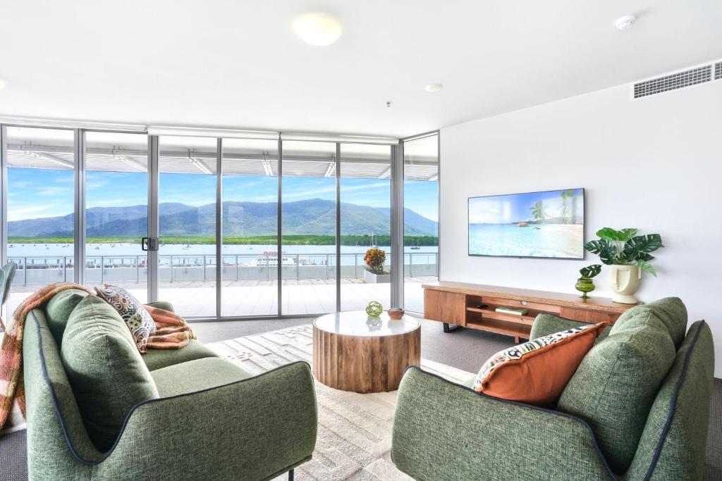 a living room with two chairs and a table at 11 Harbour Lights with Ocean Views in Cairns