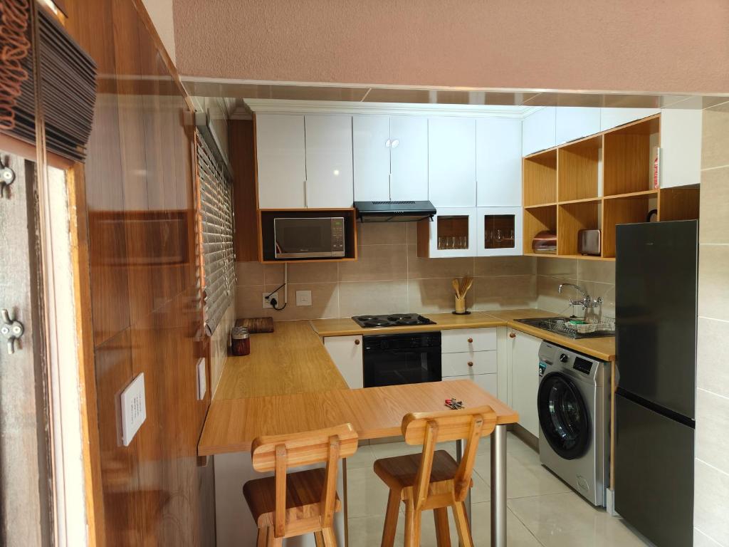 una piccola cucina con tavolo in legno e 2 sedie di Unit 89 Pendleberry Holiday Resort a Bela-Bela