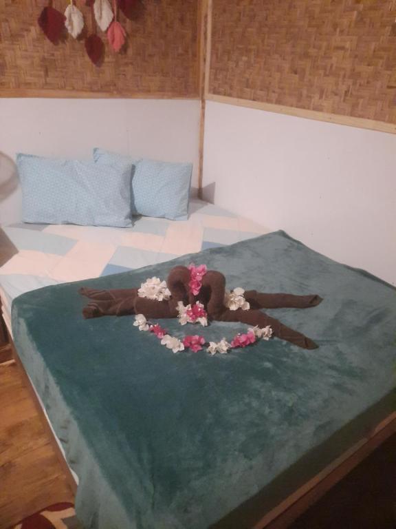 a woman laying on a bed with flowers on it at Boneputeh Homestay in Taliwang