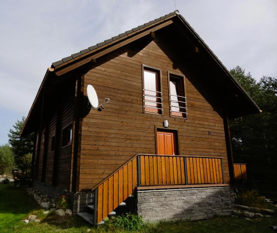 a small wooden house with a porch and two windows at Zrub Alpinus in Pribylina