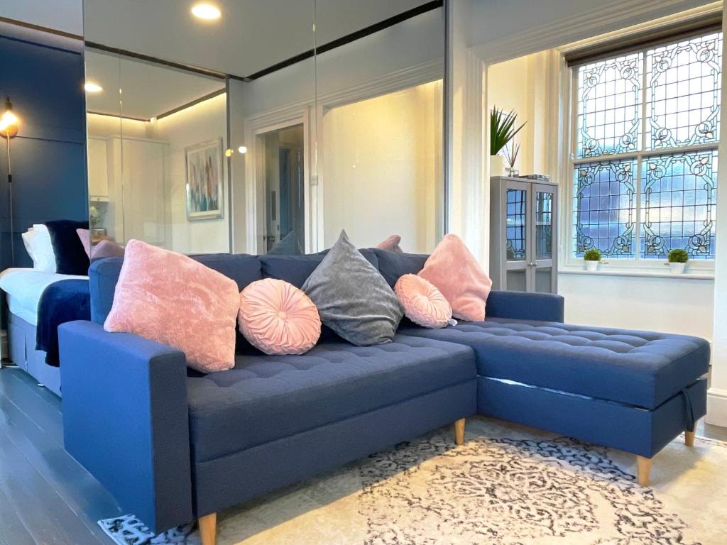 a blue couch with pillows on it in a living room at Elegant apartment in city center by HNFC Stays in Newcastle upon Tyne