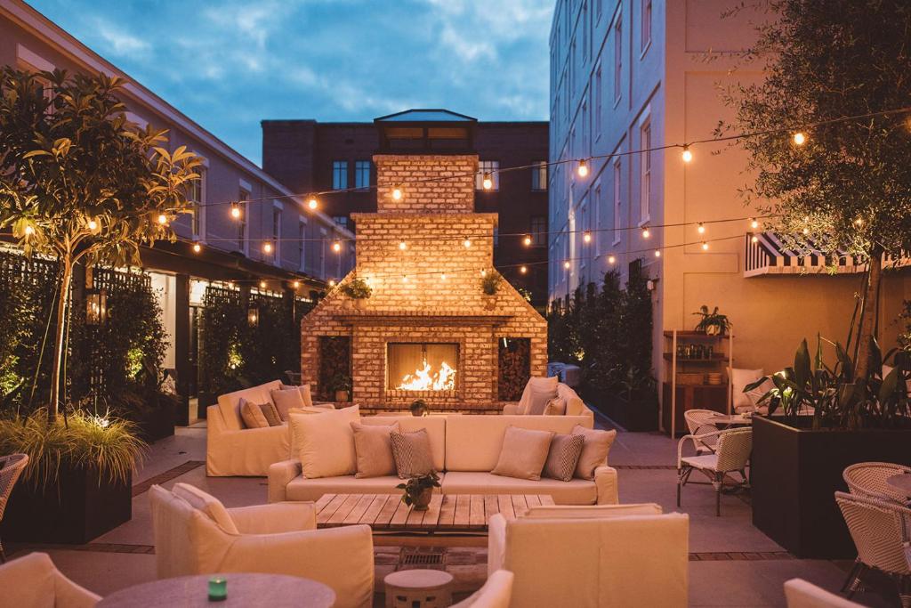 a patio with a fireplace with couches and a fire place at Hotel Emeline in Charleston