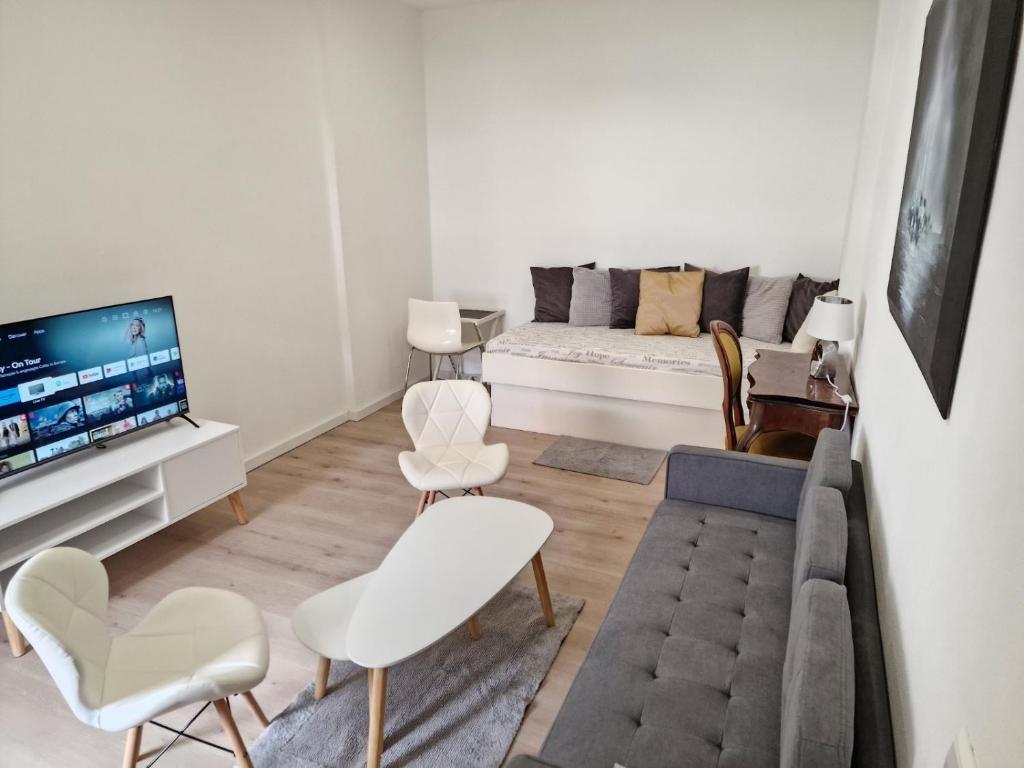 ein Wohnzimmer mit einem Sofa und einem TV in der Unterkunft Apartments bei Marienplatz in Stuttgart