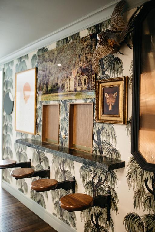 a wall with stools in a room with a mural at Hotel Emeline in Charleston