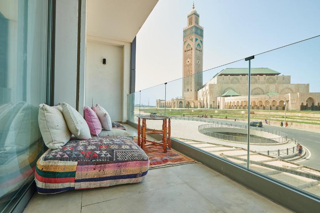 a room with a bed and a view of a clock tower at Apartment Sea View B4 - Mosquée Hassan II - By THECASAEDITION in Casablanca