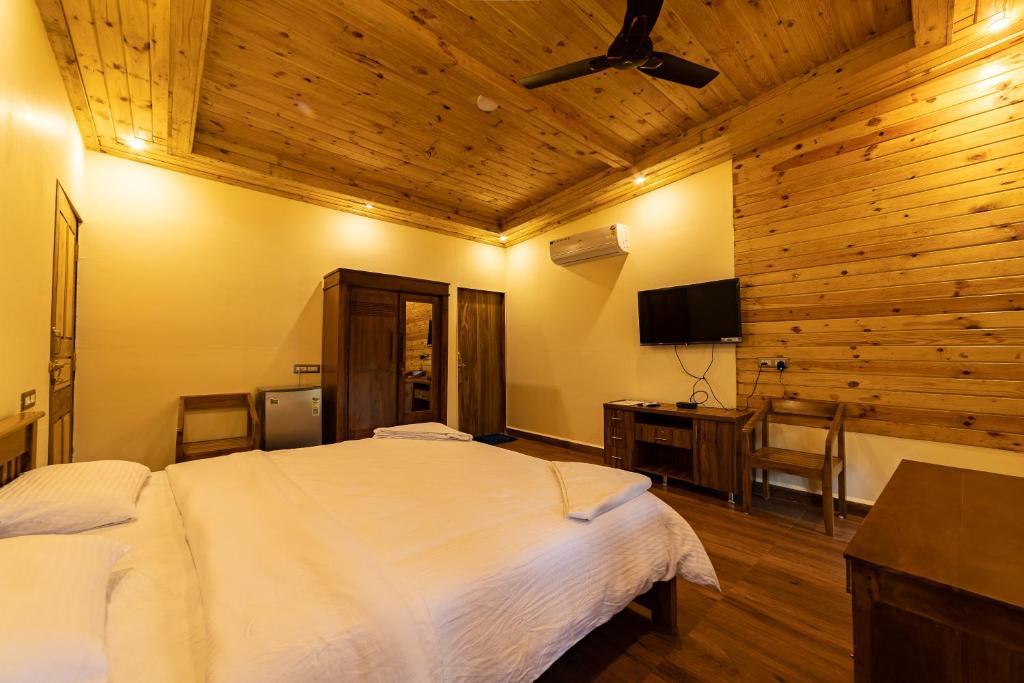 a bedroom with a white bed and a wooden ceiling at Oxygen Palolem in Palolem