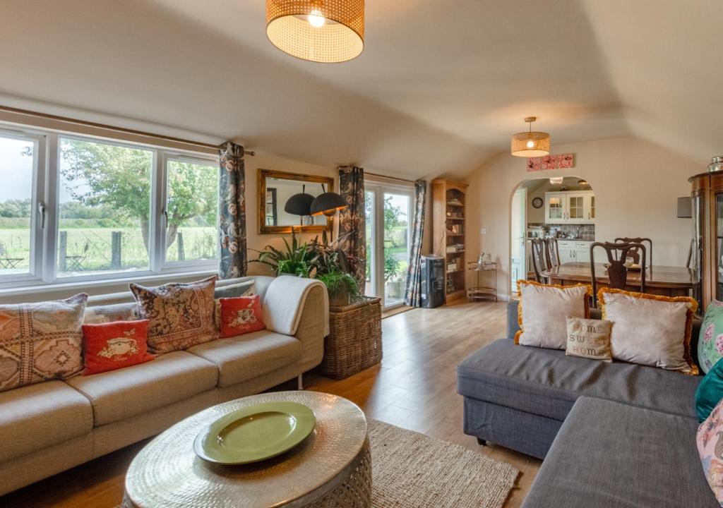 uma sala de estar com um sofá e uma mesa em Blossom Cottage em Lakenheath