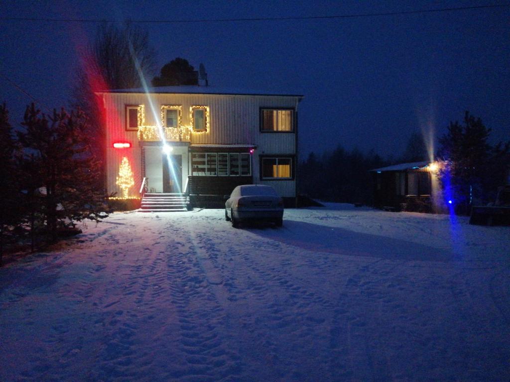 a house with a christmas tree in the snow at night at Sangis Haparandavägen 11 in Sangis