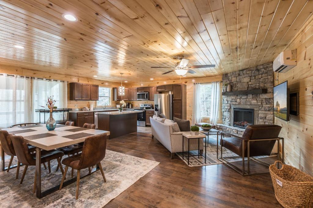 a kitchen and living room with a table and a fireplace at Brand New Luxury Cabin-Private Appalachian Retreat in Gatlinburg