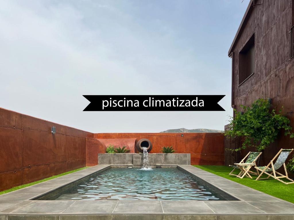 a swimming pool in a garden with a fountain at Los Naranjos - Alojamiento Rural Sostenible in El Cristo del Espíritu Santo