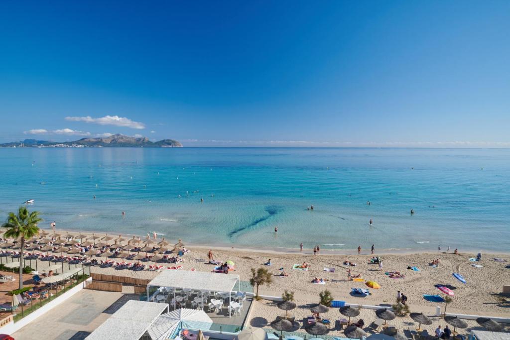Blick auf einen Strand mit Menschen im Wasser in der Unterkunft The Sea Hotel by Grupotel - Adults Only in Can Picafort
