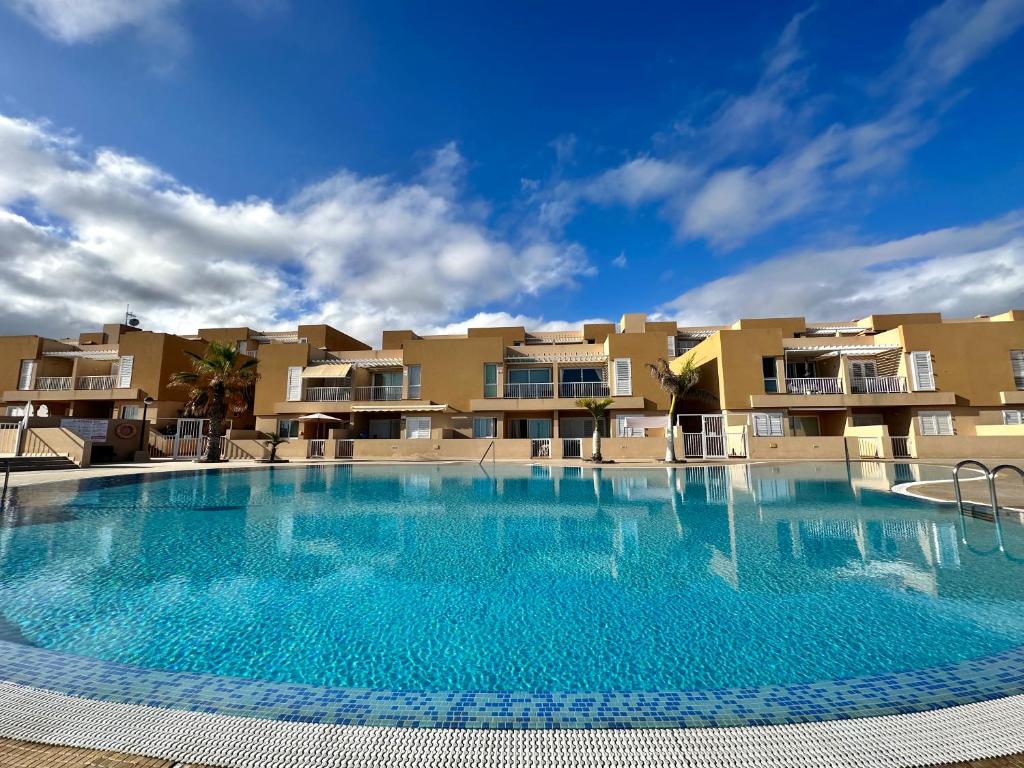a large swimming pool in front of some apartment buildings at Apartamento Vista Faro in Poris de Abona