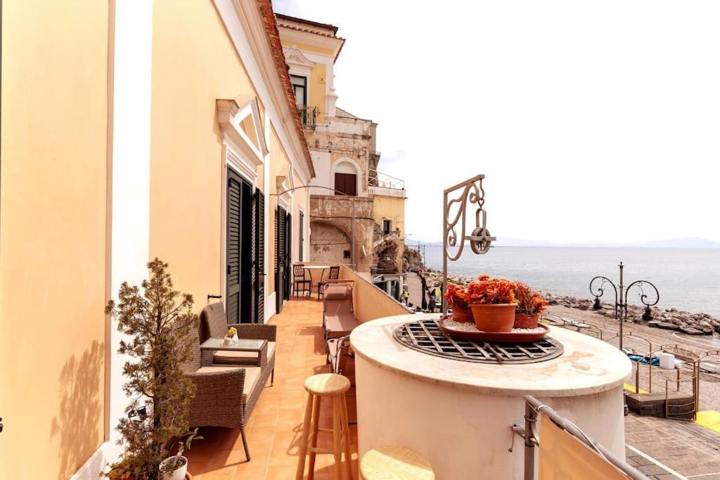 einen Balkon mit einem Tisch, Stühlen und Meerblick in der Unterkunft Casa del pozzo sulla spiaggia in Cetara