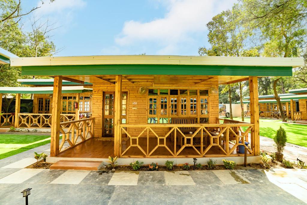 a wooden pavilion with a green roof at Oxygen Palolem in Palolem
