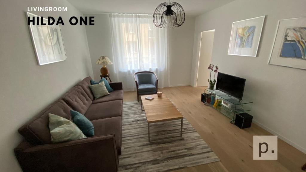 un soggiorno con divano e tavolo di H1 with 4,5 Room, Bathroom, Kitchen, Central, quiet & modern with office a Zurigo