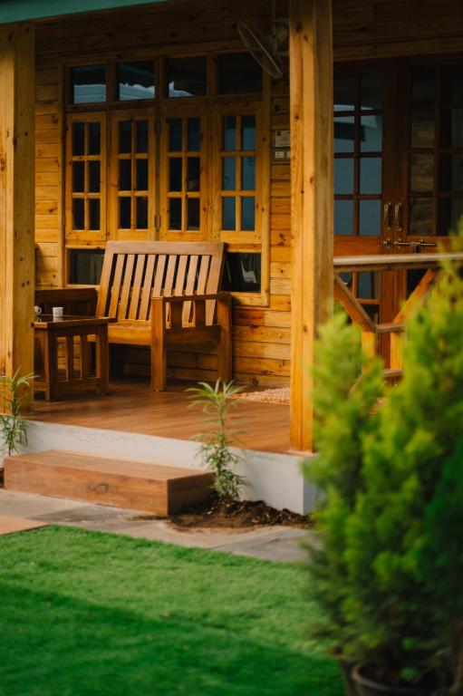 a wooden bench sitting on the porch of a cabin at Oxygen Palolem in Palolem